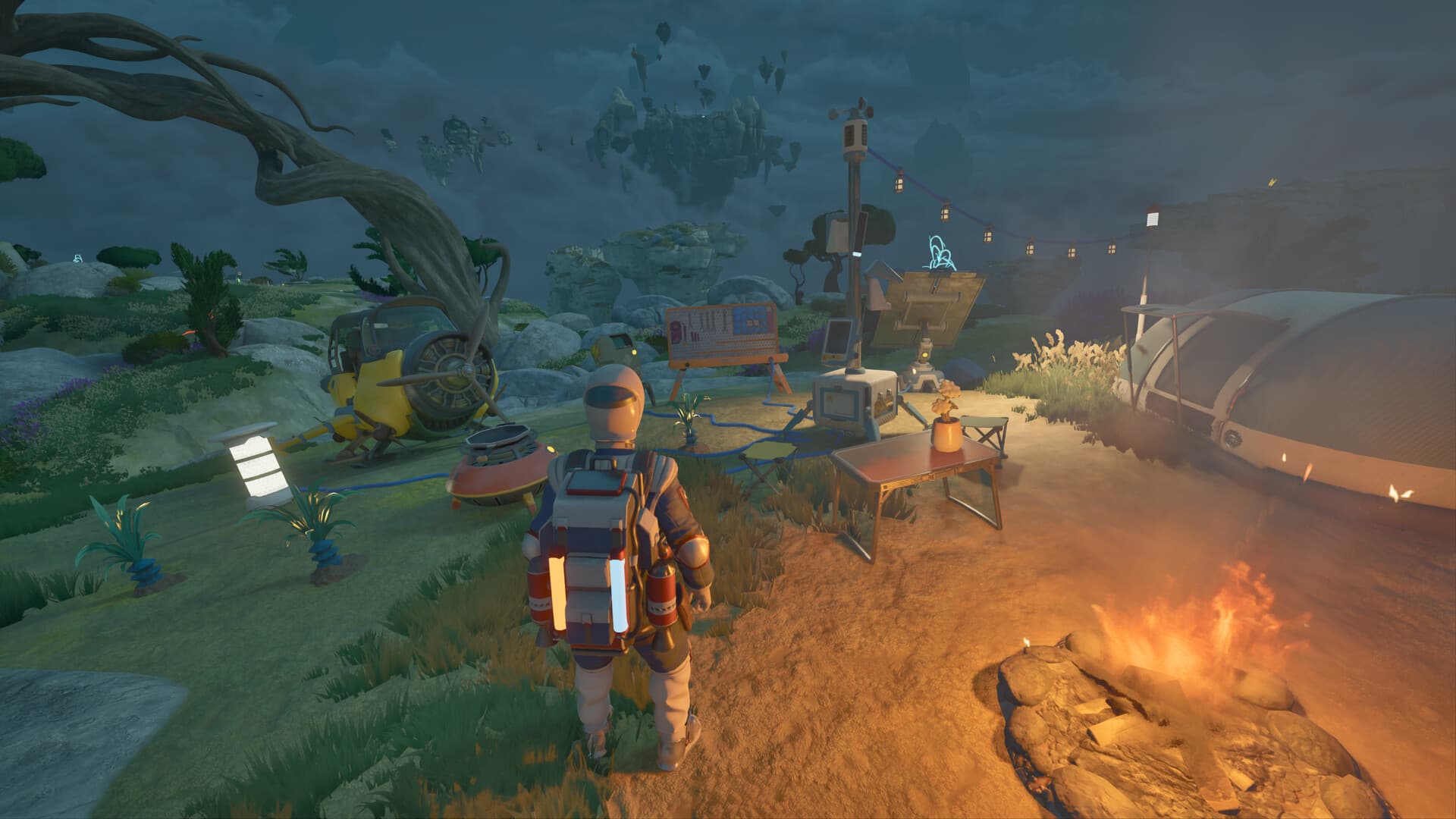 A character stands beside a campfire and equipment in a forest camp.