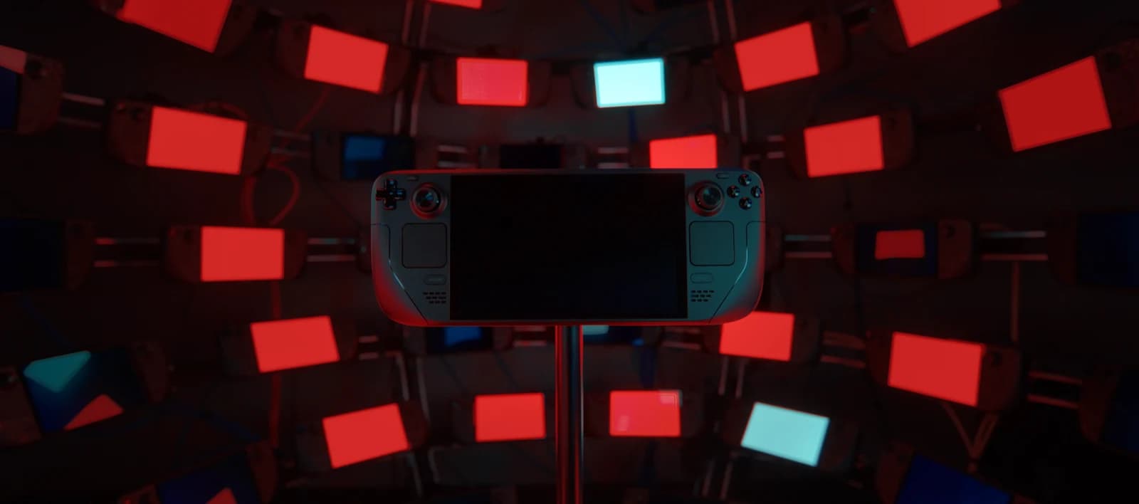 Steam Deck OLED in Valve’s press photograph, surrounded by red and blue illuminated screens.